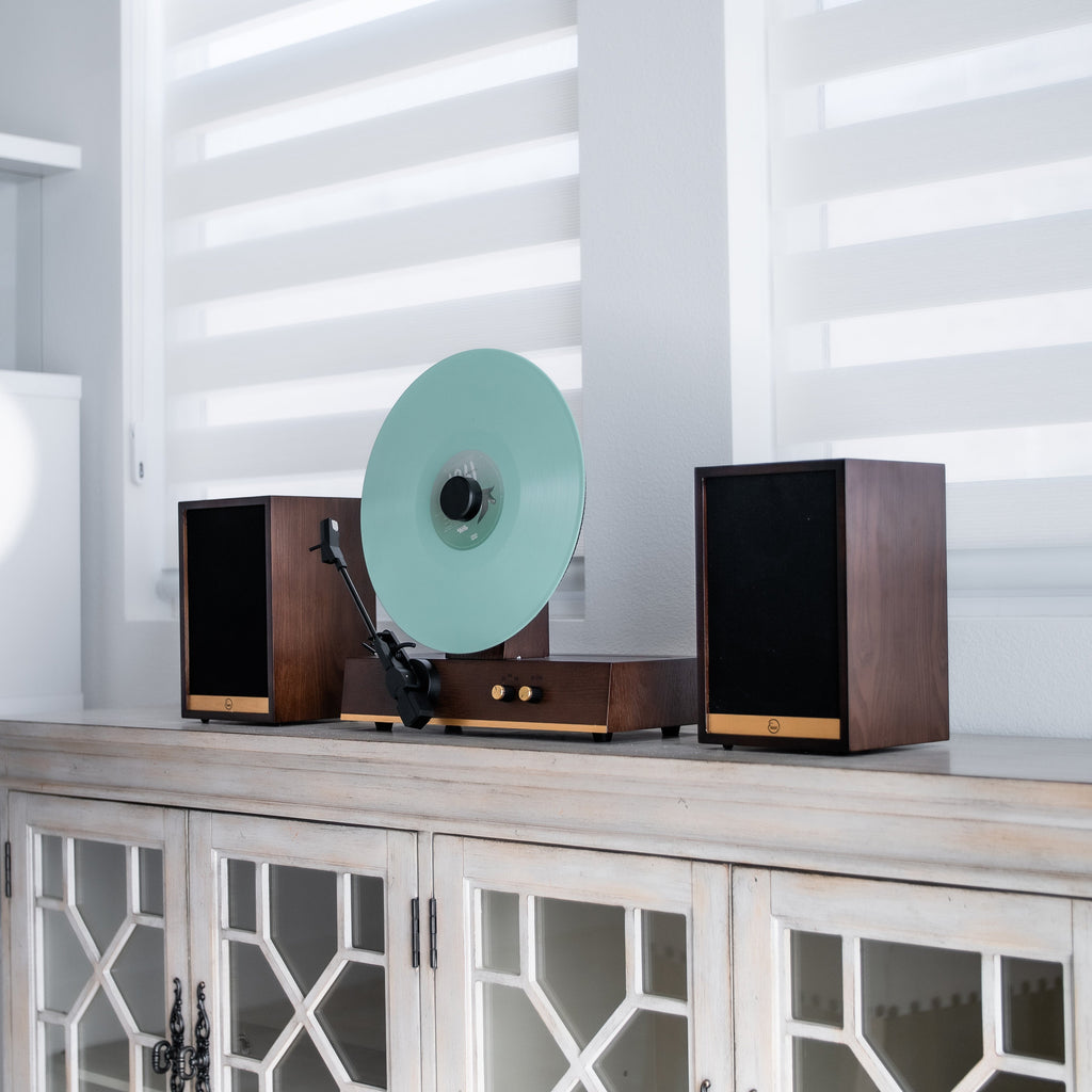 Fuse Audio GLD with a mint-colored record and two speakers beside a window