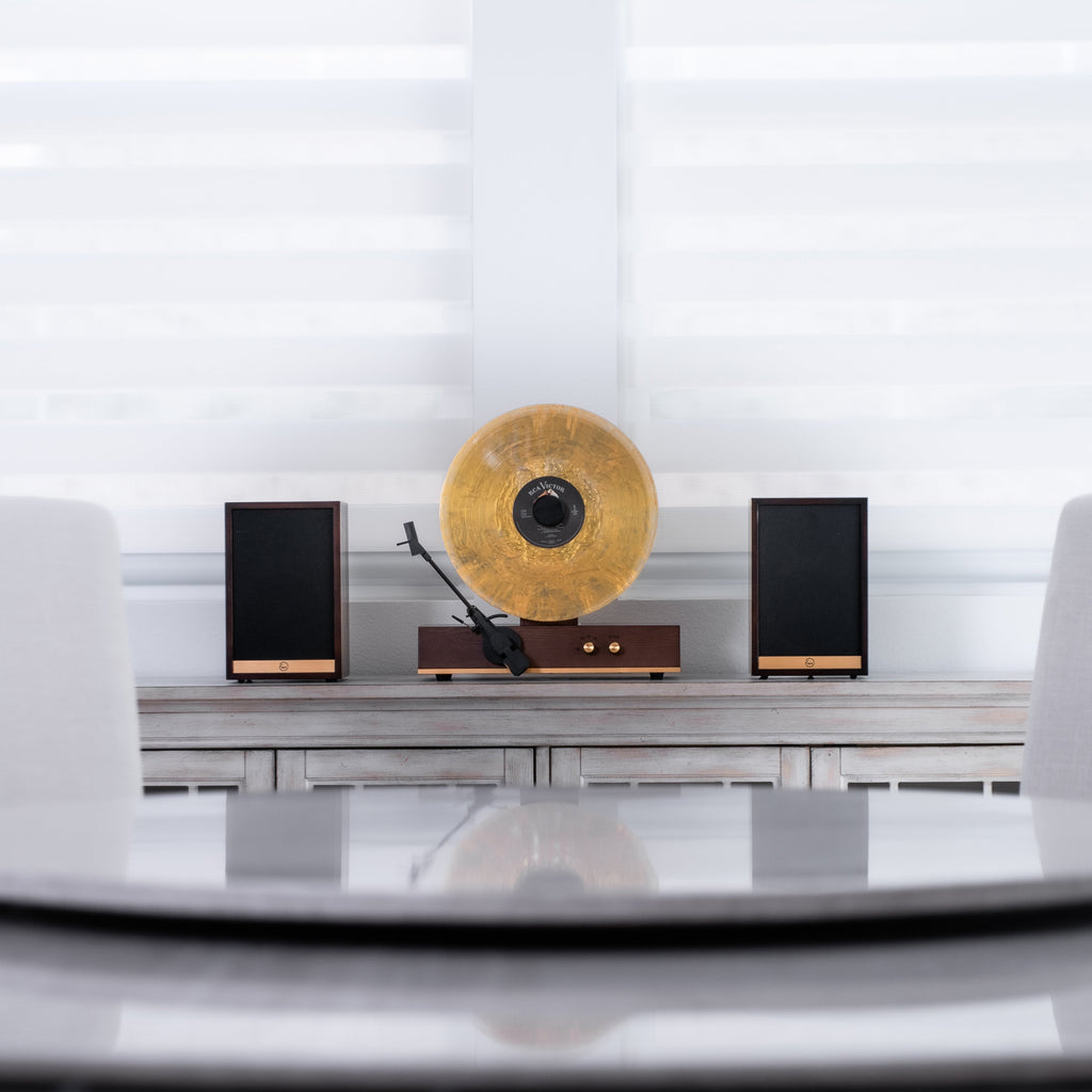 Fuse Audio GLD with a gold record and two speakers on a cabinet