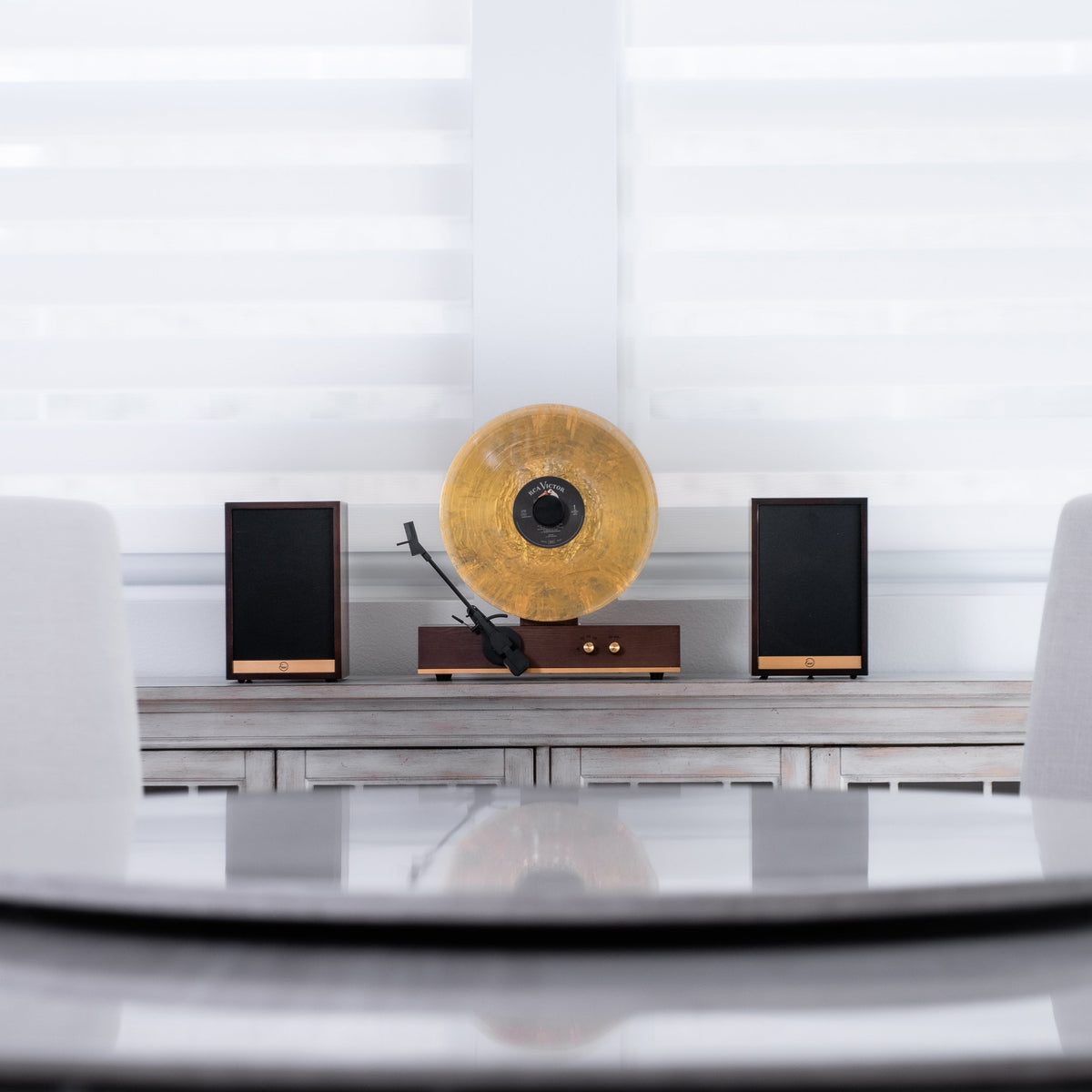 Fuse Audio GLD with a gold record and two speakers on a cabinet